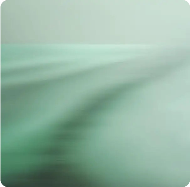 Blurred close-up of a bed with light green sheets.